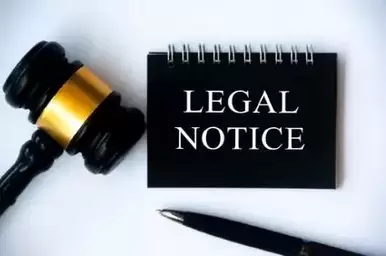 Legal notice text on black notepad with gavel and pen on white background. Legal and law concept.