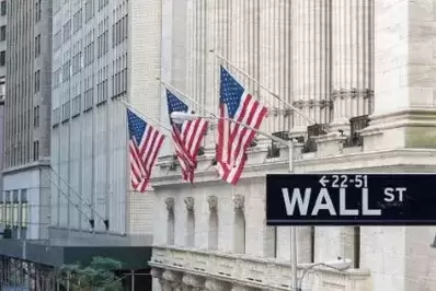 Picture of wall street with american flags in background